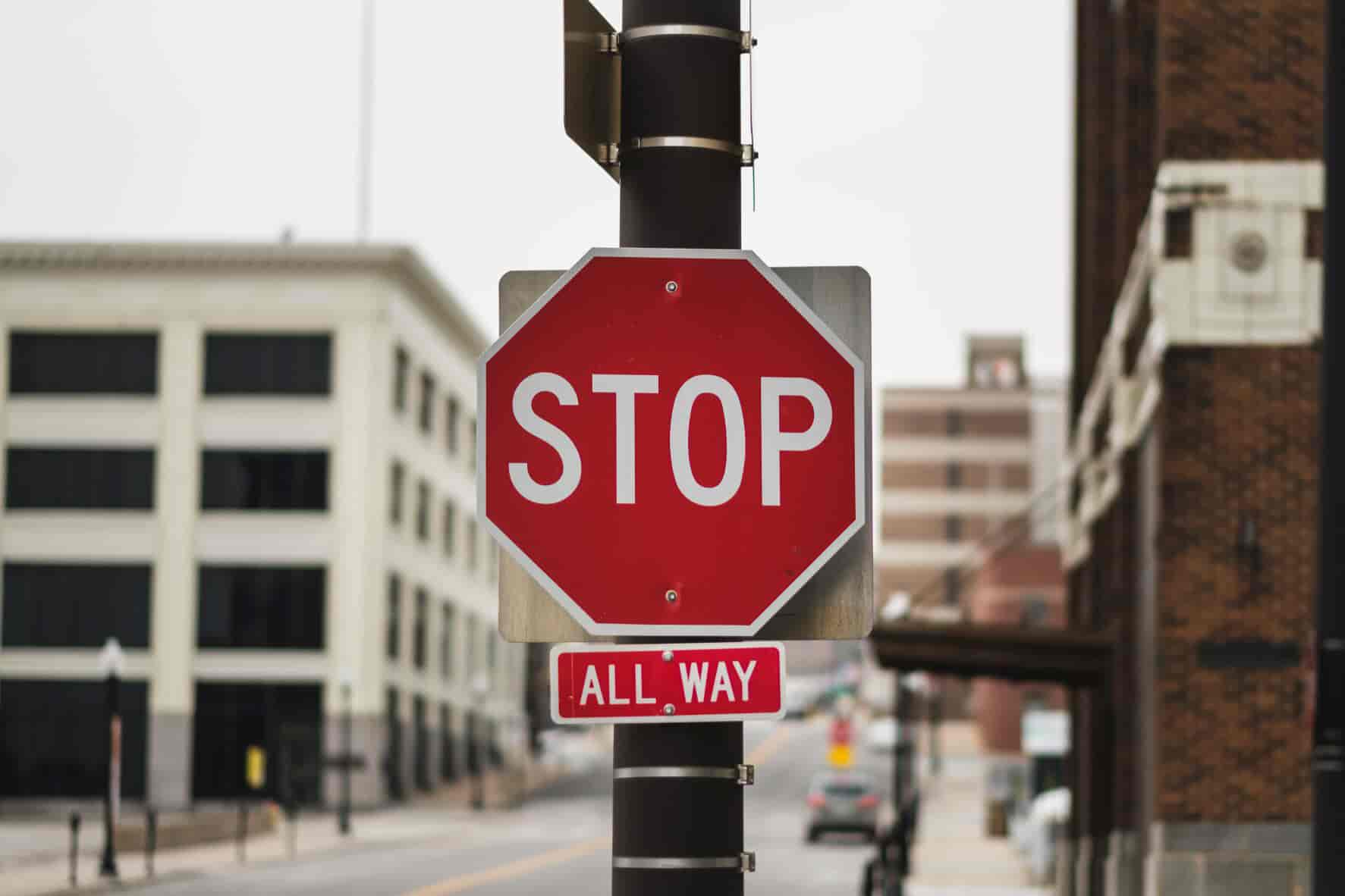 A red all-way stop sign on a city street