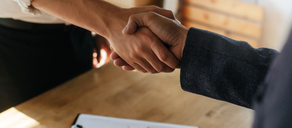 Close up of two businessmen shaking hands after discussing their contract.